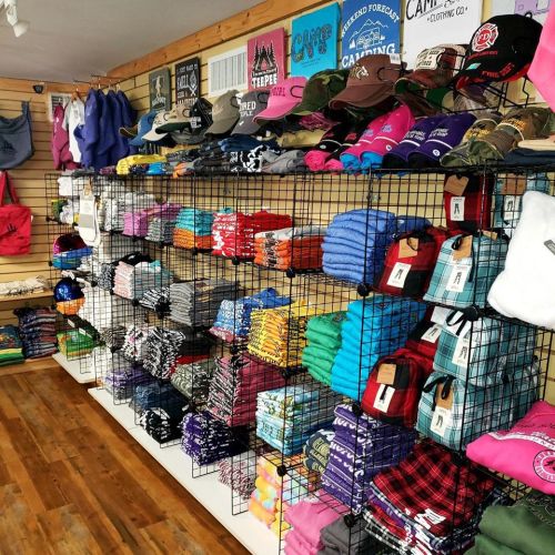 A retail display featuring colorful clothing and accessories neatly arranged on wire shelves.
