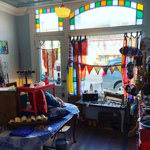 A colorful shop interior with vibrant curtains, handmade items, and decorative banners, creating a cozy atmosphere.