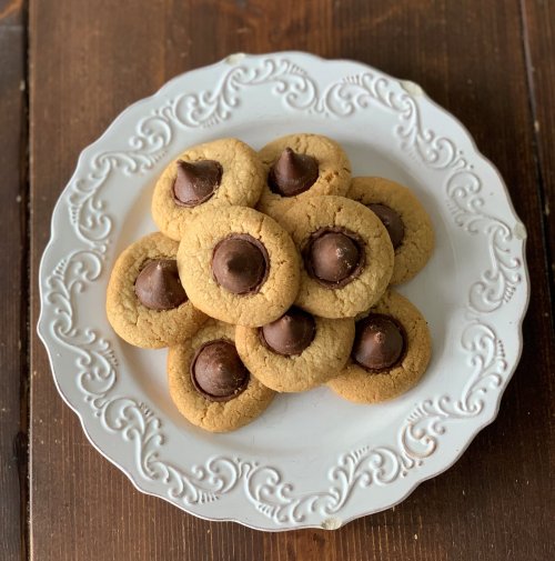 A plate of peanut butter cookies topped with chocolate kisses, arranged in a decorative pattern.