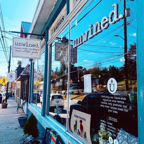 A storefront with the sign "unwined." featuring a window display of home goods and local products.