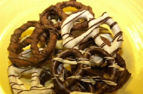 A plate of chocolate-covered pretzels drizzled with white and dark chocolate.