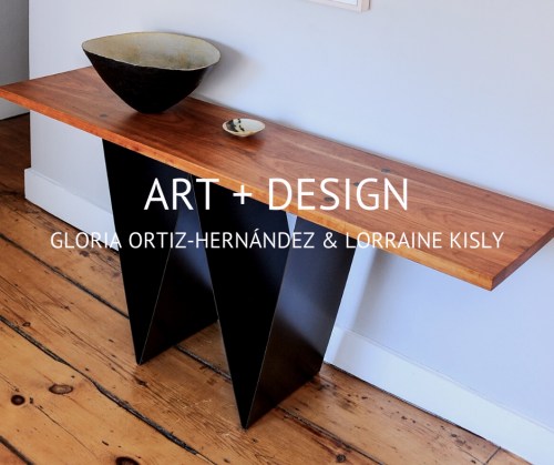 A wooden console table with a black geometric base, featuring a bowl and plate on top, with text about the artists.