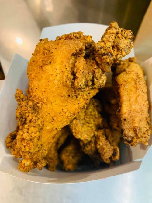 A box filled with crispy, golden-brown fried chicken wings.
