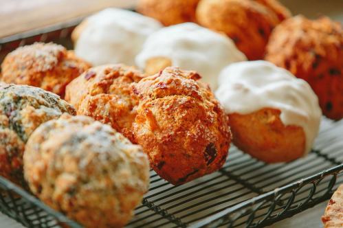 A variety of freshly baked muffins on a wire rack, featuring different toppings and textures.