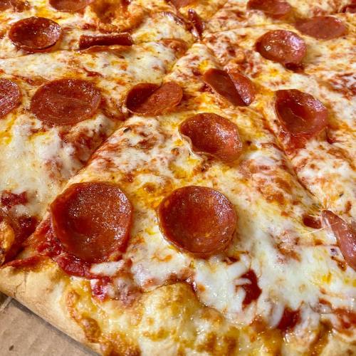 Close-up of a pizza with melted cheese and pepperoni slices on a golden crust.