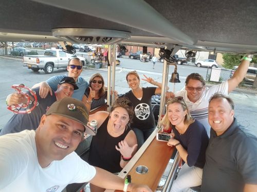 A group of smiling friends enjoying a fun outing on a party bus, with drinks and laughter all around.