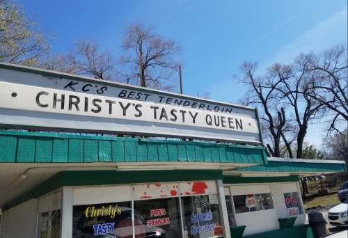 Sign for Christy's Tasty Queen, advertising "KC's Best Tenderloin," with a clear blue sky in the background.