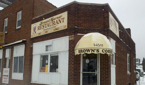 Exterior of Brown's Corner Restaurant, featuring a brick facade and a snow-covered awning.