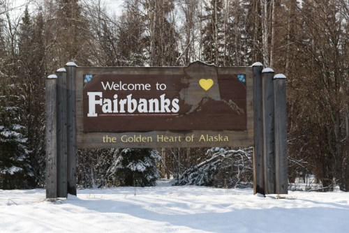 Welcome sign for Fairbanks, Alaska, featuring a heart and surrounded by snow-covered trees.