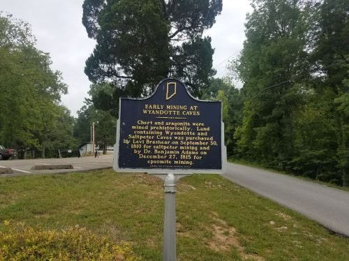 Historical marker about early mining at Wyandotte Caves, detailing land purchase and notable dates.