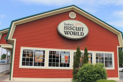 Exterior of Tudor's Biscuit World, a red building with large windows and a prominent sign.