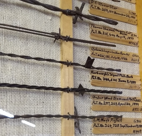 Display of various historical patents and tools, featuring labeled metal rods and their patent dates on a fabric background.