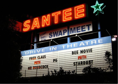 Neon sign for Santee Drive-In Theatre featuring movie titles: "Fred Claus," "Mr. Woodcock," "Bee Movie," and "Stardust."