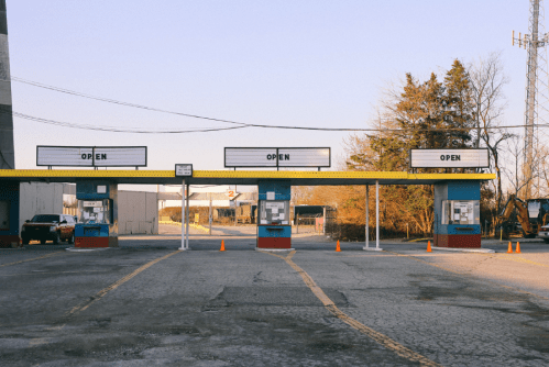 An empty toll booth area with three open lanes and a clear sky in the background.