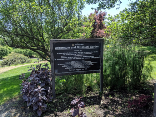 Sign for an Arboretum and Botanical Garden, detailing its purpose and welcoming visitors to enjoy the area.