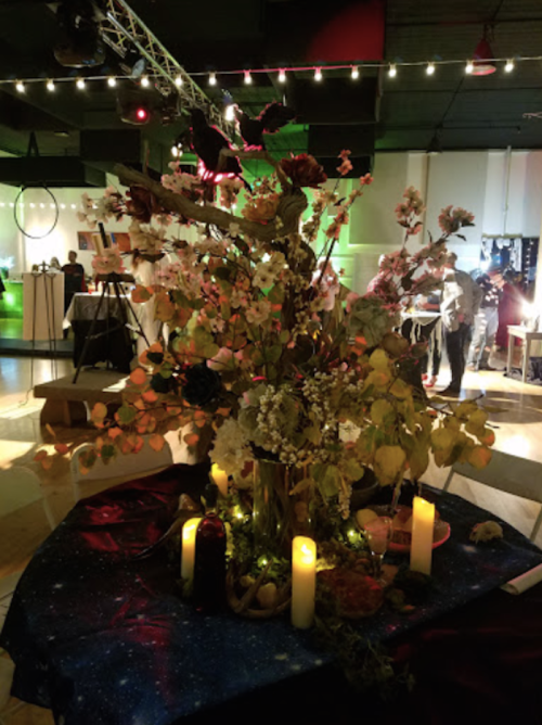 A beautifully arranged table centerpiece with flowers, candles, and decorative elements in a festive event setting.