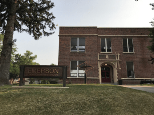 Brick building with large windows and a sign reading "Emerson Center for the Arts & Culture" in a grassy area.