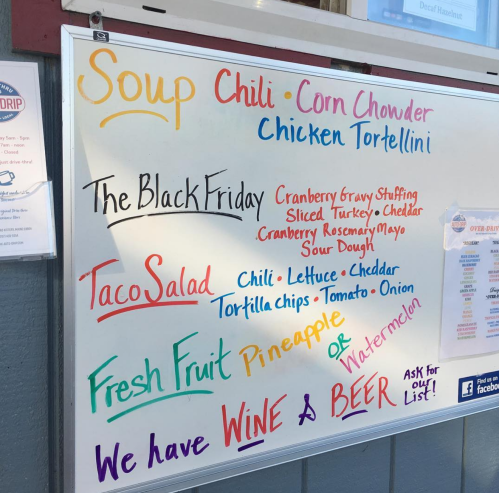 Menu board featuring soups, chili, taco salad, and drinks like wine and beer, with special items highlighted.