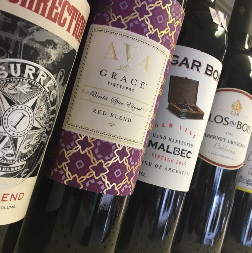 A row of wine bottles featuring various labels, including a red blend and Malbec from Argentina.