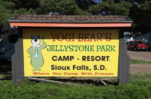 Sign for Yogi Bear's Jellystone Park, featuring a cartoon bear and text about camping and resort in Sioux Falls, S.D.