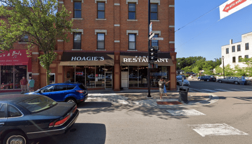 Exterior view of Hoagie's Family Restaurant on a busy street, with cars parked and pedestrians walking by.