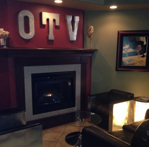 Cozy lounge area featuring a fireplace, modern furniture, and decorative wall art.