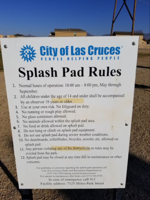 Sign listing the Splash Pad rules for the City of Las Cruces, including hours, age restrictions, and safety guidelines.