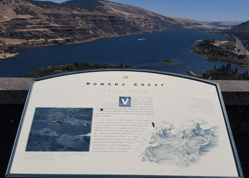 A scenic view of the Columbia River Gorge from Rowena Crest, featuring an informational sign about ice age floods.