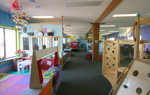 Brightly colored playroom with various toys, climbing structures, and soft play areas, designed for children's activities.