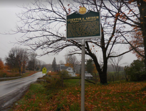 Historical marker for Chester A. Arthur, 21st President, near a rural road with autumn foliage and a house in the background.