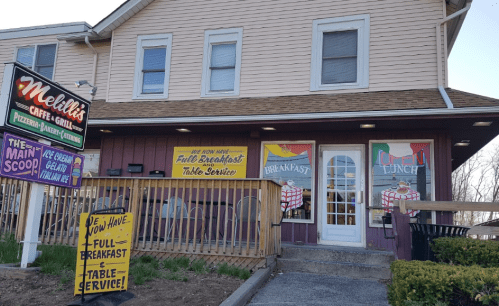 Exterior of Melilli's Café & Grill, featuring signs for breakfast, lunch, and ice cream, with a welcoming entrance.