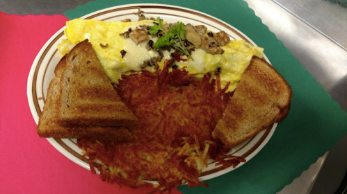 A plate featuring a cheese omelet, hash browns, and two slices of toasted bread on a colorful background.
