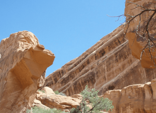 A rocky landscape with layered sandstone formations under a clear blue sky.