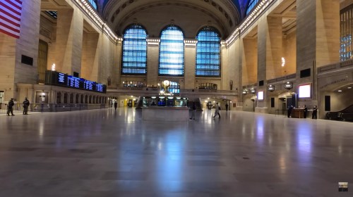 Grand Central Terminal interior featuring high ceilings, large windows, and a spacious, empty concourse.