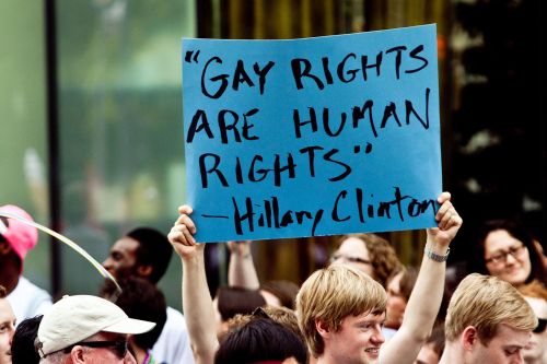 A crowd holds a blue sign reading, "Gay rights are human rights" - Hillary Clinton, during a rally.