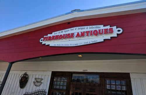Sign for Firehouse Antiques, featuring "Over 40,000 Square Feet of Antiques & Collectibles" on a red building.