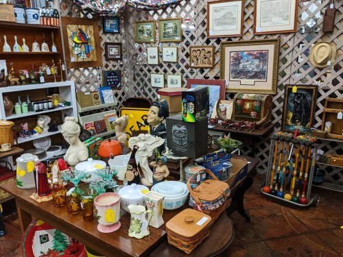 A cozy antique shop filled with various collectibles, including pottery, figurines, and vintage decor items.