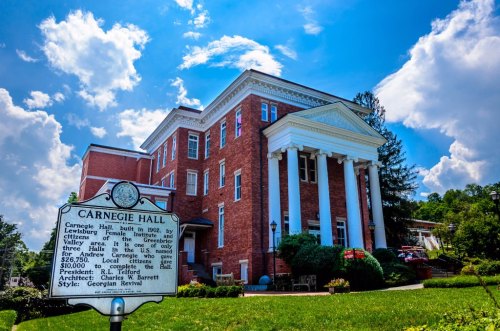 Historic Carnegie Hall, built in 1902, features Georgian Revival architecture and a sign detailing its history.
