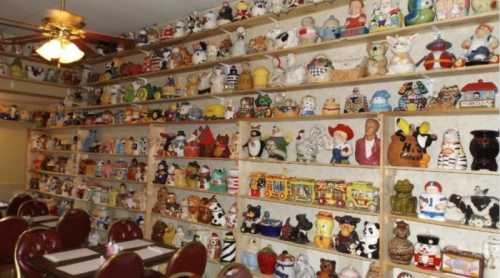 A wall filled with colorful ceramic figurines and collectibles, with tables and chairs in the foreground.