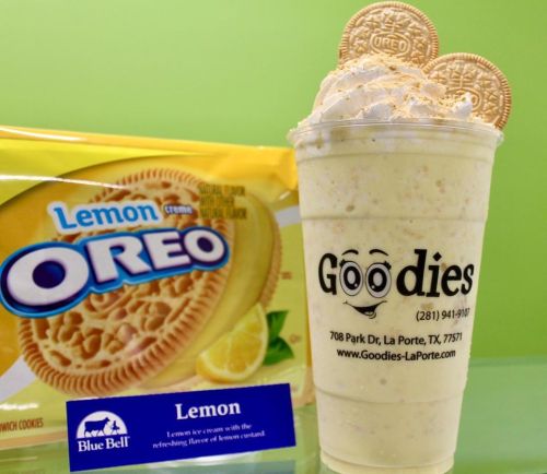 A creamy lemon milkshake topped with Oreo cookies, next to a pack of Lemon Creme Oreos and a Blue Bell ice cream label.