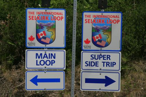 Two signs for the International Selkirk Loop, indicating directions for "Main Loop" and "Super Side Trip."