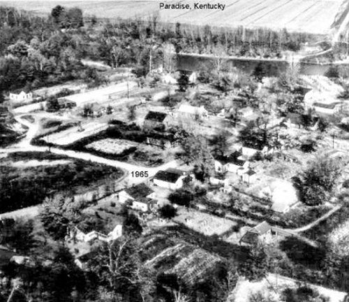 Aerial view of Paradise, Kentucky, in 1965, showing houses, fields, and a river in the background.