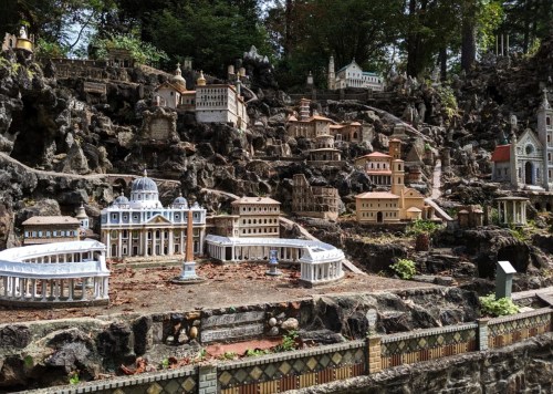 A miniature village with detailed buildings set among rocky terrain and greenery.