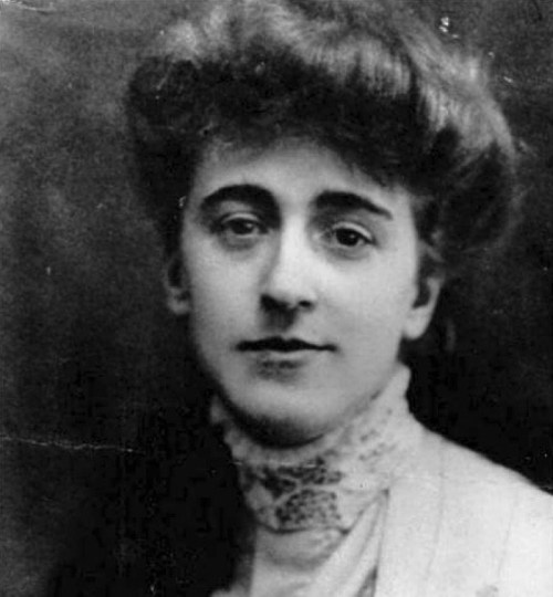 Black and white portrait of a young woman with wavy hair, wearing a high-collared blouse and a thoughtful expression.