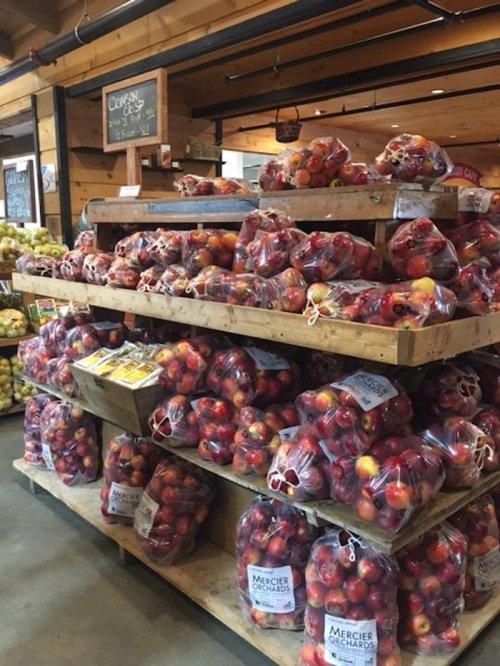 A display of bags filled with apples stacked on wooden crates in a market.