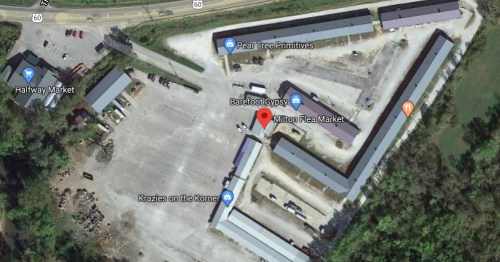 Aerial view of Milton Flea Market and surrounding businesses, with parking and access roads visible.