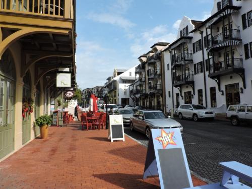 A charming street lined with shops and restaurants, featuring outdoor seating and classic architecture.