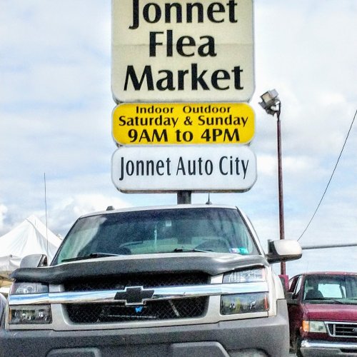 Sign for Jonnet Flea Market and Jonnet Auto City, with hours and details about indoor and outdoor shopping.
