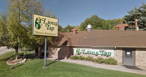 Exterior of Lions Tap restaurant with a sign reading "Famous Hamburgers" and a landscaped area in front.