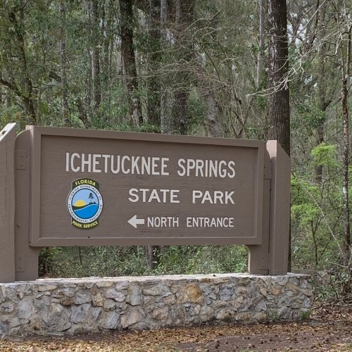 Sign for Ichetucknee Springs State Park, indicating the North Entrance, surrounded by trees.